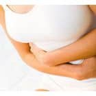 Asmuo, vilkintis baltą viršutinę dalį, abiem rankomis įsikimba į pilvą, o tai rodo, kad gali patirti diskomfortą pilve. Dėmesys sutelkiamas į liemenį ir rankas, nerodant žmogaus veido.