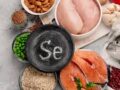 Įvairūs selenu turtingi maisto produktai, tarp kurių ypač išsiskiria natūralus selenas – nuo lašišos ir vištienos iki migdolų, avižų ir granatų – išdėstyti ant šiferio lėkštės, ant kurios užrašyta „Se“.
